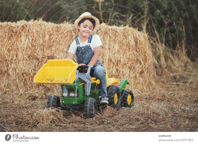 Kind, das mit Spielzeugtraktor auf Wiese spielt Lifestyle Spielen Kinderspiel Garten Gartenarbeit Landwirtschaft Forstwirtschaft Mensch Kleinkind Junge Kindheit