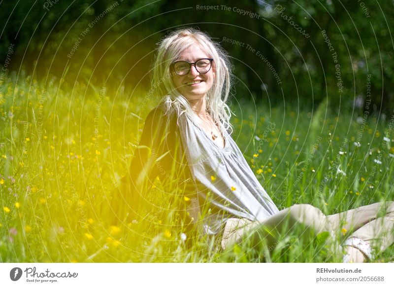 Frau mit Dreads sitzt auf einer Wiese Porträt Jugendliche Junge Frau feminin Mensch Blick in die Kamera Oberkörper Natur Umwelt Rastalocken sitzen Landschaft