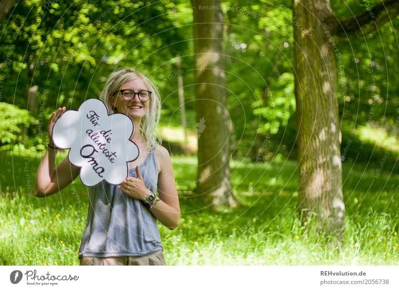 Frau mit einem Schild im Park Großmutter Junge Frau Jugendliche feminin 18-30 Jahre Erwachsene Schönes Wetter Sommer Natur Wiese Brille Schilder & Markierungen