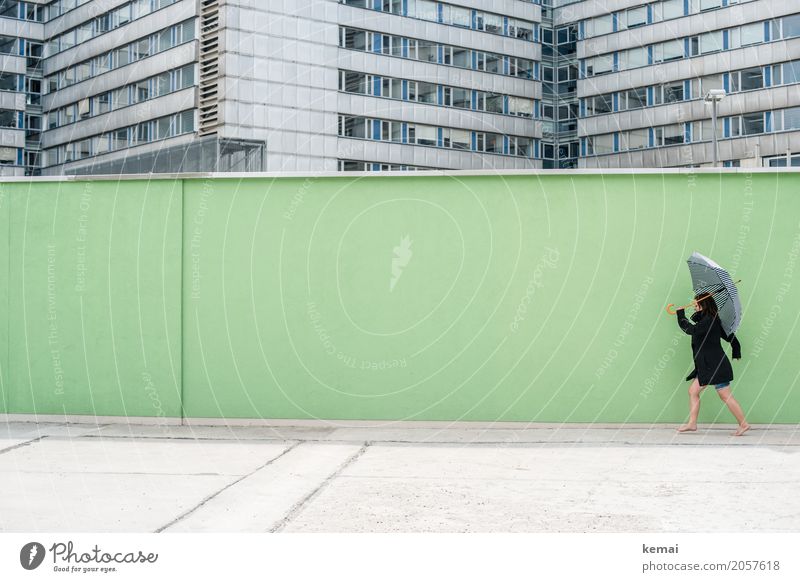 Frau mit Regenschirm vor grüner Wand, im Hintergrund Hochhäuser Stil Freizeit & Hobby Spielen Ausflug Freiheit Städtereise Mauer Mensch feminin Erwachsene Leben
