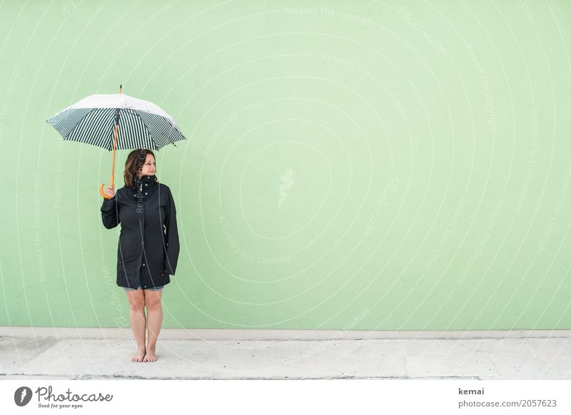 Frau mit Regenschirm vor grüner Wand Lifestyle Stil harmonisch Wohlgefühl Zufriedenheit Erholung ruhig Freizeit & Hobby Ferien & Urlaub & Reisen Ausflug