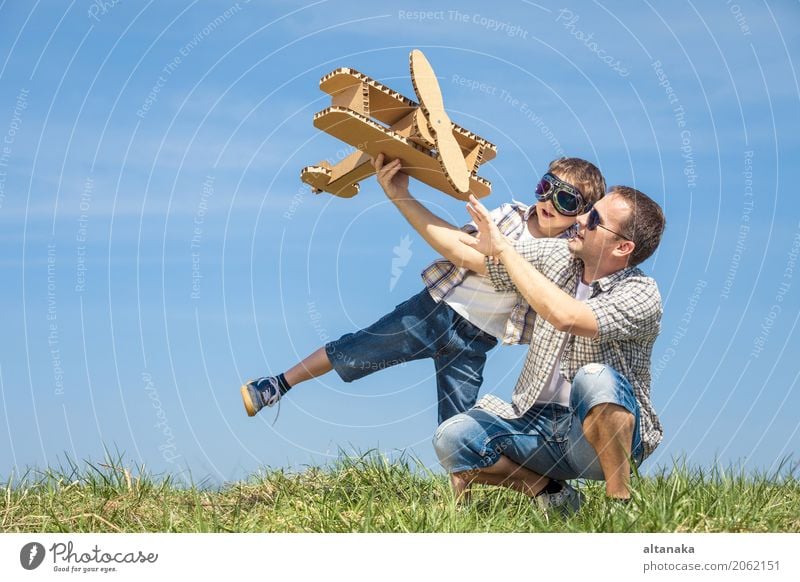 Vater und Sohn, die mit Pappspielzeugflugzeug spielen Lifestyle Freude Glück Leben Freizeit & Hobby Spielen Ferien & Urlaub & Reisen Abenteuer Freiheit Sommer