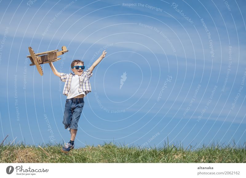 Kleiner Junge, der mit Pappspielzeugflugzeug spielt Lifestyle Freude Glück Spielen Ferien & Urlaub & Reisen Abenteuer Freiheit Sommer Sonne Sport Erfolg Kind