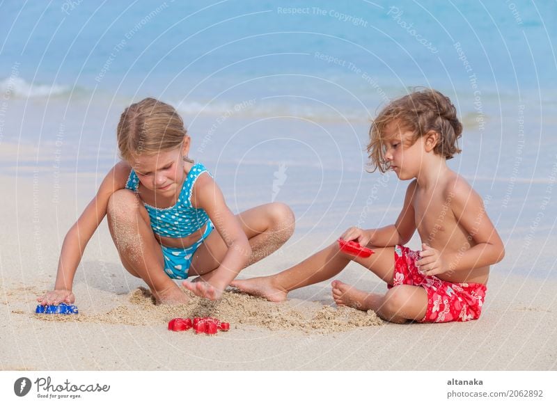 Zwei glückliche Kinder, die auf dem Strand spielen Lifestyle Freude Glück schön Erholung Freizeit & Hobby Spielen Ferien & Urlaub & Reisen Freiheit Sommer Sonne