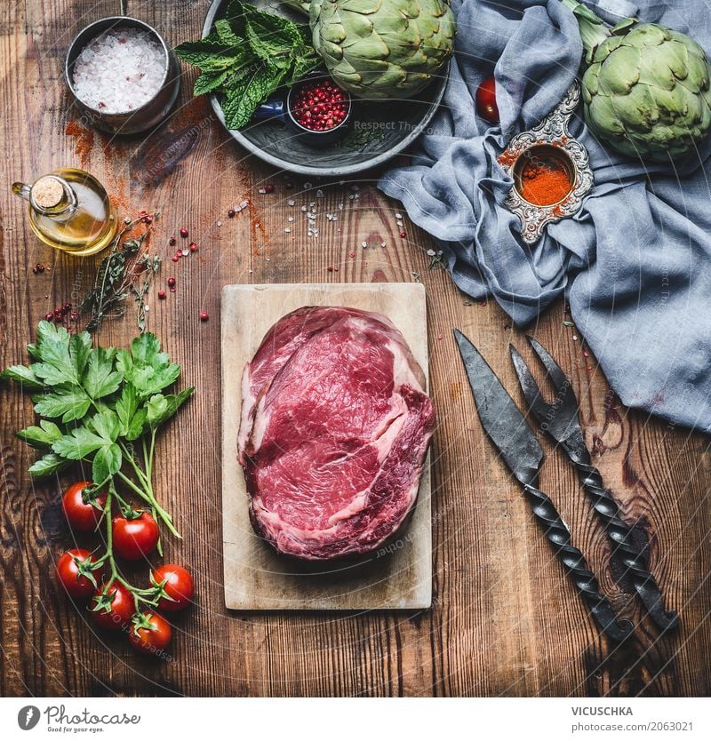 Rohes Fleisch Steaks mit Zutaten fürs Grillen oder Kochen Lebensmittel Gemüse Kräuter & Gewürze Öl Ernährung Bioprodukte Geschirr Messer Gabel Stil Design