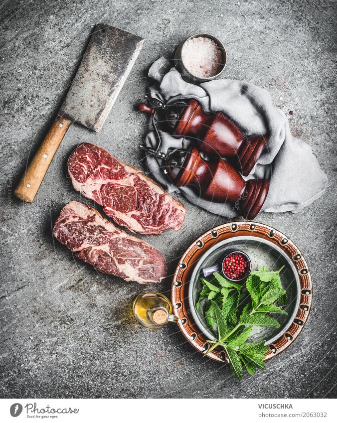 Marmorierte Ribeye Steaks auf dem Küchentisch Lebensmittel Fleisch Kräuter & Gewürze Ernährung Mittagessen Abendessen Bioprodukte Geschirr Messer Stil Design