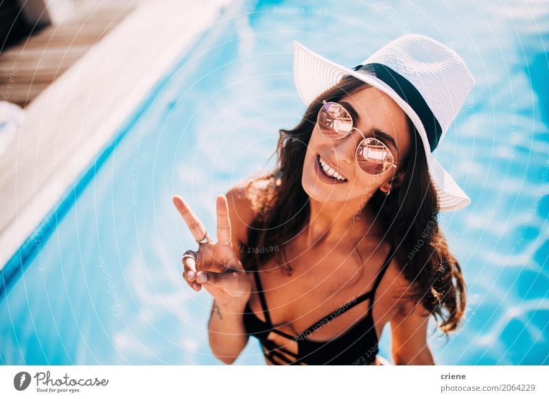 Frau, die das Friedenszeichen steht im Swimmingpool macht Lifestyle Freude Glück Erholung Schwimmbad Ferien & Urlaub & Reisen Freiheit Sommer Mensch feminin