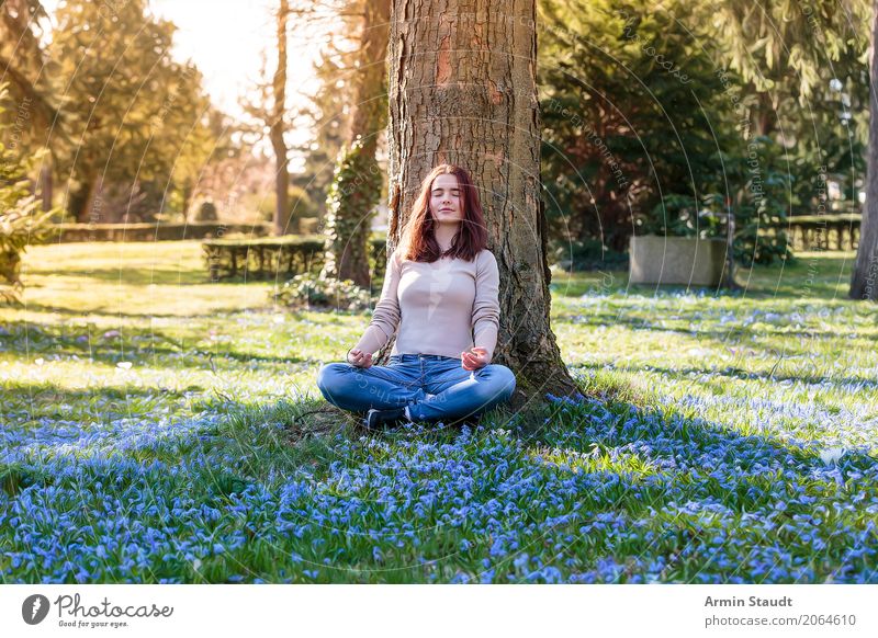 junge Frau meditiert unter einem Baum auf einer Frühlingswiese Lifestyle Stil Freude Glück Gesundheit Leben stimmig Wohlgefühl Zufriedenheit Sinnesorgane