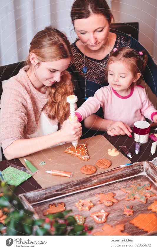 Familie schmückt gebackene Weihnachts-Lebkuchen mit Zuckerguss Dekoration & Verzierung Tisch Küche Feste & Feiern Kind Mensch Frau Erwachsene