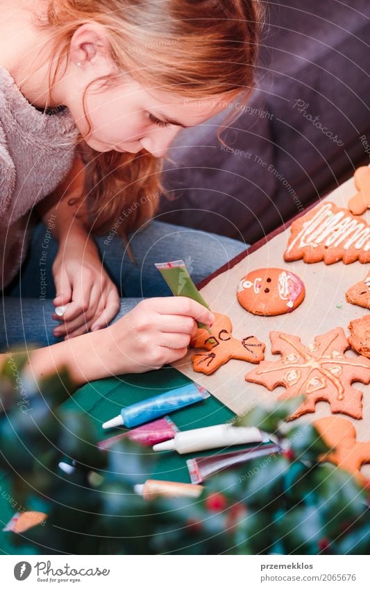 Mädchen, das Weihnachtslebkuchenplätzchen mit Schokolade verziert Lebensmittel Lifestyle Dekoration & Verzierung Tisch Feste & Feiern Weihnachten & Advent