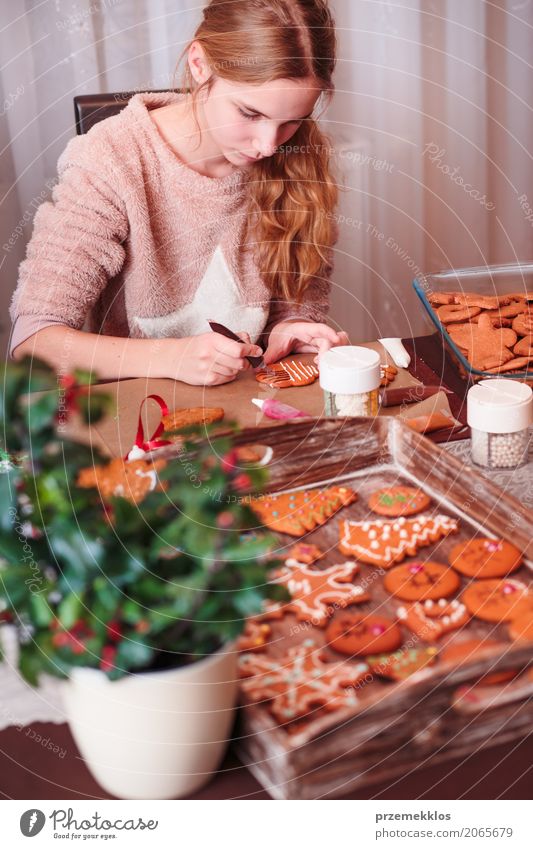 Mädchen, das Weihnachtslebkuchenplätzchen mit dem Zuckerguss verziert Lifestyle Dekoration & Verzierung Tisch Küche Feste & Feiern Mensch 1 8-13 Jahre Kind