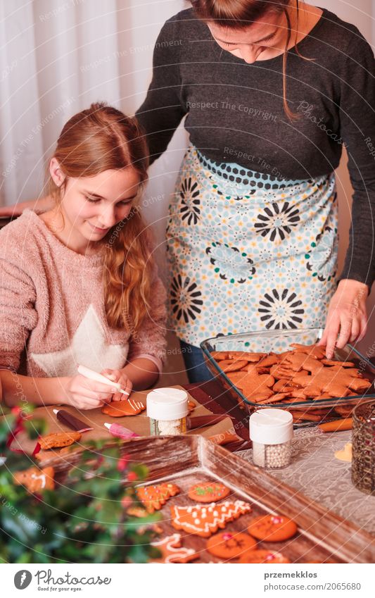 Mädchen, das Weihnachtslebkuchenplätzchen mit dem Zuckerguss verziert Dekoration & Verzierung Tisch Küche Feste & Feiern Kind Mensch Frau Erwachsene