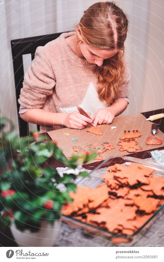 Mädchen, das Weihnachtslebkuchenplätzchen mit Schokolade verziert Lifestyle Dekoration & Verzierung Tisch Küche Feste & Feiern Weihnachten & Advent Mensch 1