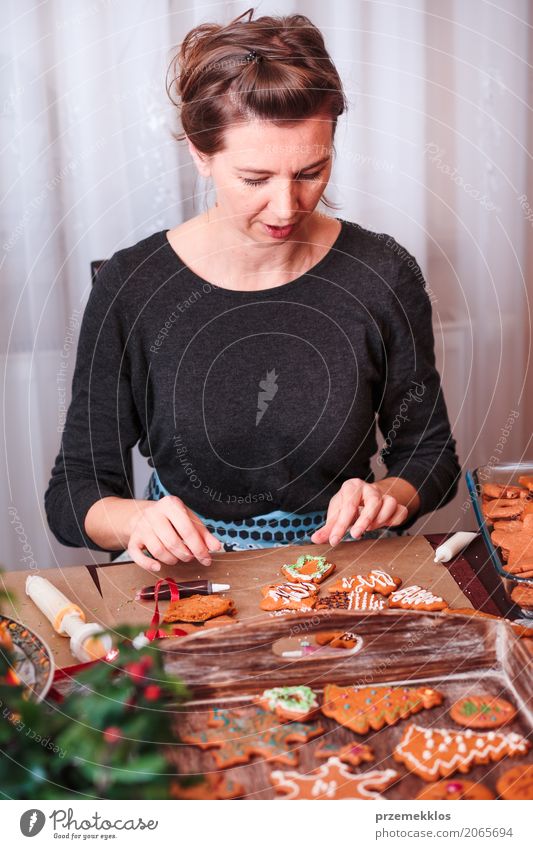 Frau, die gebackene Weihnachtslebkuchen mit dem Bereifen verziert Lifestyle Dekoration & Verzierung Tisch Küche Feste & Feiern Weihnachten & Advent Mensch