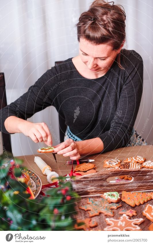 Frau, die gebackenen Weihnachtslebkuchen mit dem Bereifen verziert Lebensmittel Tisch Küche Feste & Feiern Weihnachten & Advent Mensch Erwachsene 1 30-45 Jahre