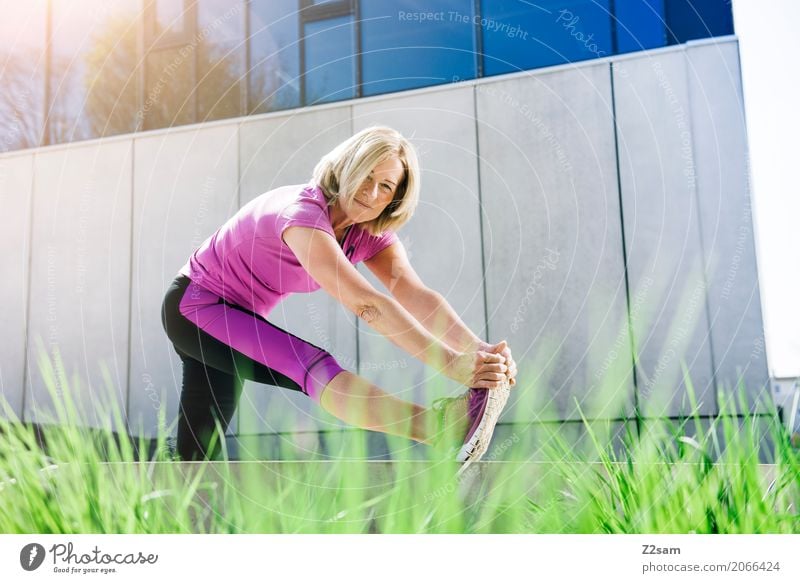 Rentnerin beim Stretching Freizeit & Hobby Sport Fitness Sport-Training Yoga Frau Erwachsene Weiblicher Senior 45-60 Jahre Sträucher Stadt Turnschuh blond