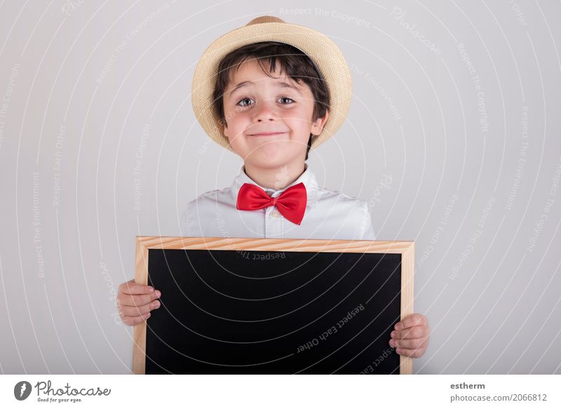 lächelndes Kind, das eine Tafel hält Lifestyle Freude Schulkind Mensch maskulin Kleinkind Junge 1 3-8 Jahre Kindheit Krawatte Hut festhalten Lächeln schreiben