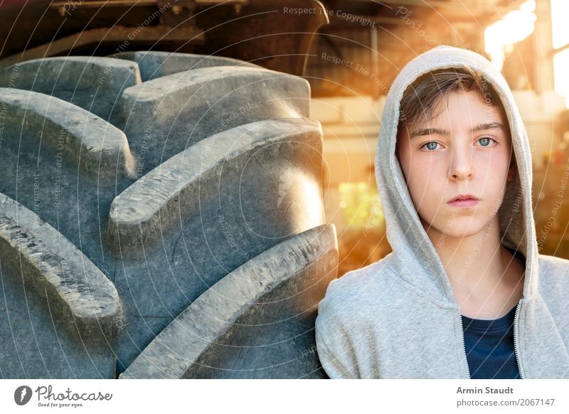 Porträt eines jungen Mannes der an einem Tracktorreifen lehnt Lifestyle Stil schön ruhig Sommer Mensch maskulin Junger Mann Jugendliche 1 13-18 Jahre Traktor