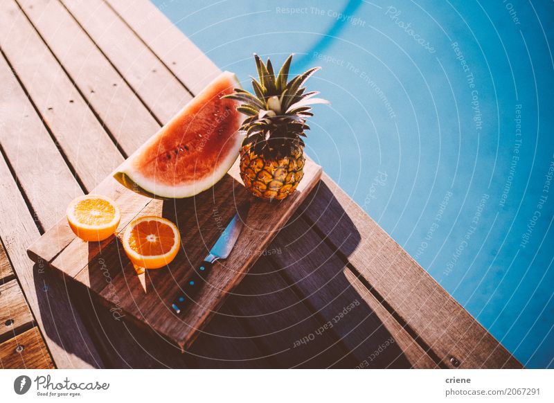Platte mit tropischen Früchten neben Swimmingpool Lebensmittel Frucht Orange Ernährung Essen Teller Lifestyle Schwimmbad Schwimmen & Baden Freizeit & Hobby