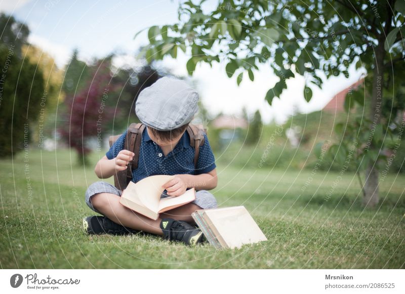 Schulanfang Kind Junge Kindheit 1 Mensch 3-8 Jahre entdecken lernen lesen sitzen Einschulung Mütze Schulranzen Buch Garten Außenaufnahme Schule Farbfoto