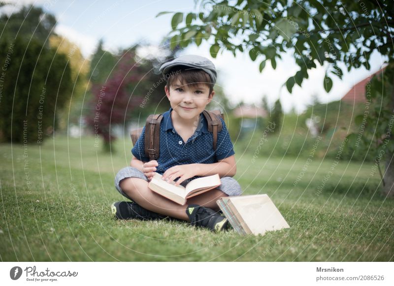 Schulanfang Mensch Kind Junge Kindheit Leben 1 3-8 Jahre Lächeln lernen sitzen Mütze Einschulung Buch antik Schulranzen Wiese Garten Außenaufnahme sommerlich