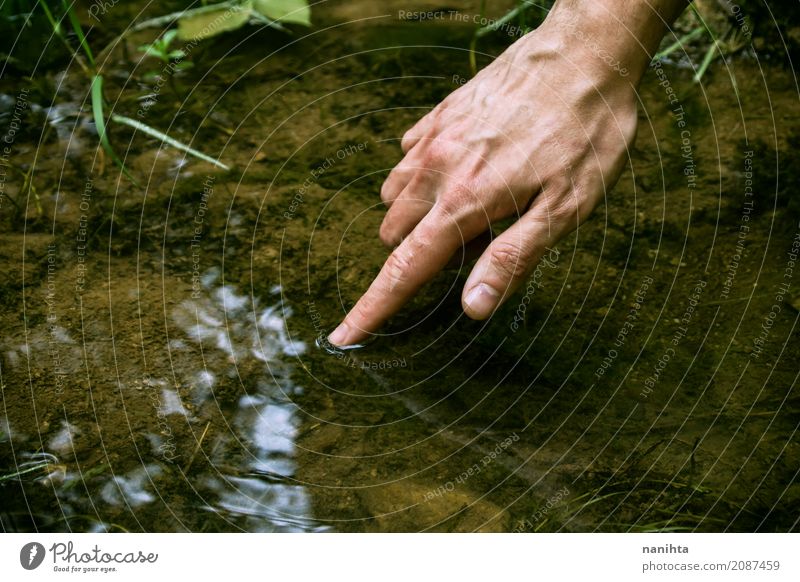 Hand, die frisches Brunnenwasser berührt Mensch maskulin Junger Mann Jugendliche Finger Umwelt Natur Urelemente Wasser Frühling Sommer Seeufer berühren