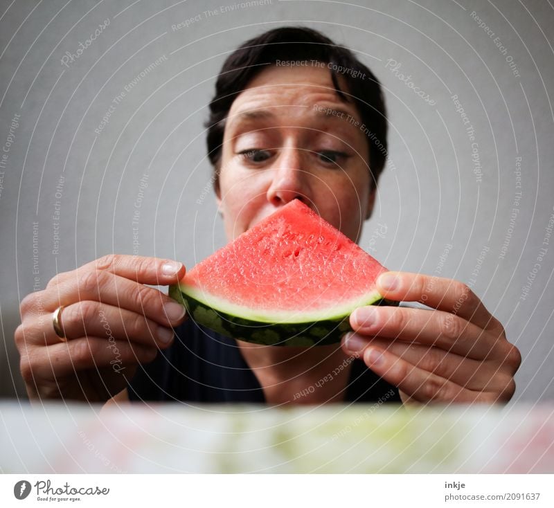 Not so young caucasian woman now almost biting in watermelon Frucht Wassermelone Melonen Ernährung Essen Vegetarische Ernährung Fingerfood Frau Erwachsene Leben