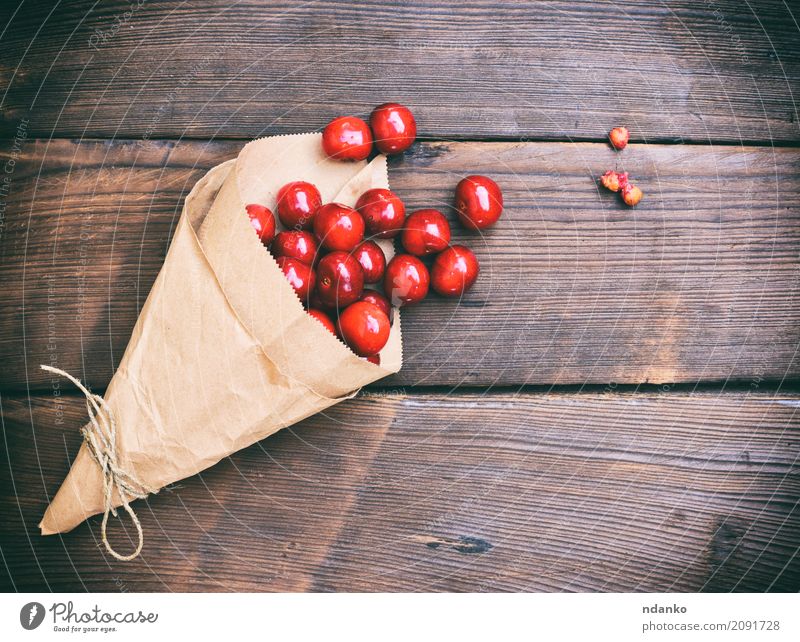 Reife rote Kirsche in einer Papiertüte Frucht Dessert Vegetarische Ernährung Holz Diät Essen frisch retro saftig Hintergrund Beeren Lebensmittel Ernte viele