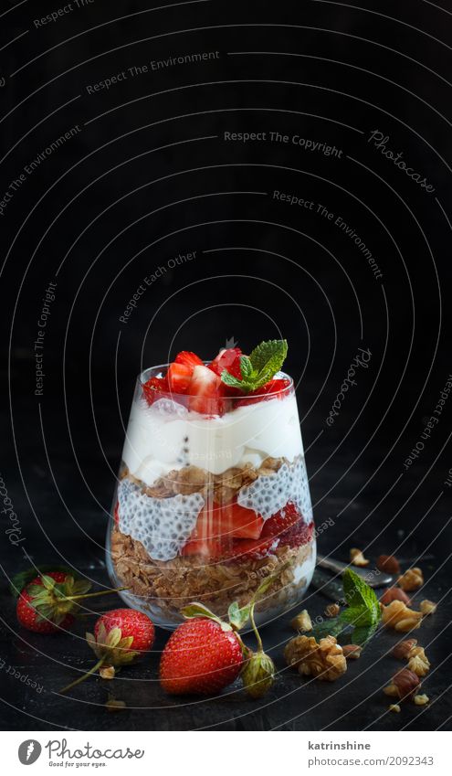 Chia Pudding Erdbeerparfait mit griechischem Joghurt und Nüssen Frucht Dessert Frühstück Diät Glas Löffel dunkel rot weiß Beeren Müsli Samen Molkerei