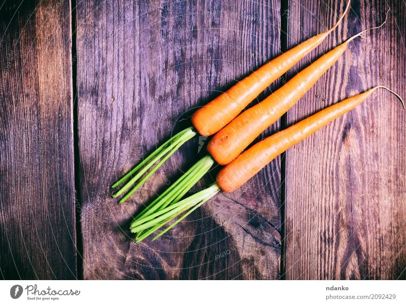 Drei frische Karotten Gemüse Ernährung Essen Vegetarische Ernährung Diät Tisch Natur Pflanze Holz natürlich grün reif nützlich Ackerbau organisch orange