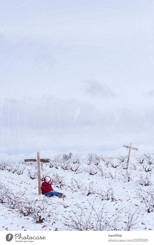 Eine Person, die auf einem Kreuz auf einem schneebedeckten Gebiet sich lehnt Mensch feminin Junge Frau Jugendliche 1 18-30 Jahre Erwachsene Umwelt Natur