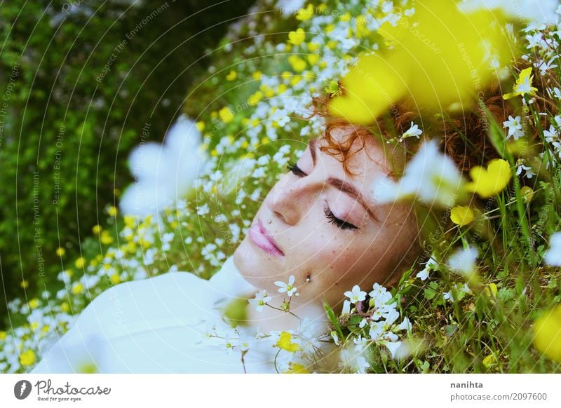 Junge Frau, die auf einem Gebiet der Blumen schläft Lifestyle Freude Gesicht Sommersprossen Wellness Wohlgefühl Sinnesorgane Erholung Meditation Duft
