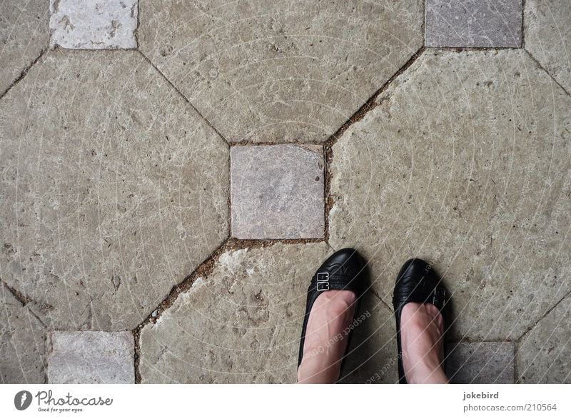 gestörte Symmetrie Mensch feminin Frau Erwachsene Fuß Platz Boden Bodenbelag Schuhe Damenschuhe Stein stehen grau schwarz Quadrat parallel Muster Achteck