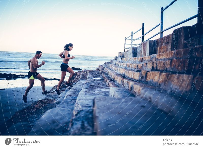 Geeignete junge erwachsene Paare, die zusammen am Strand laufen Lifestyle Freude sportlich Fitness Freizeit & Hobby Meer Sport Mensch Frau Erwachsene Mann 2