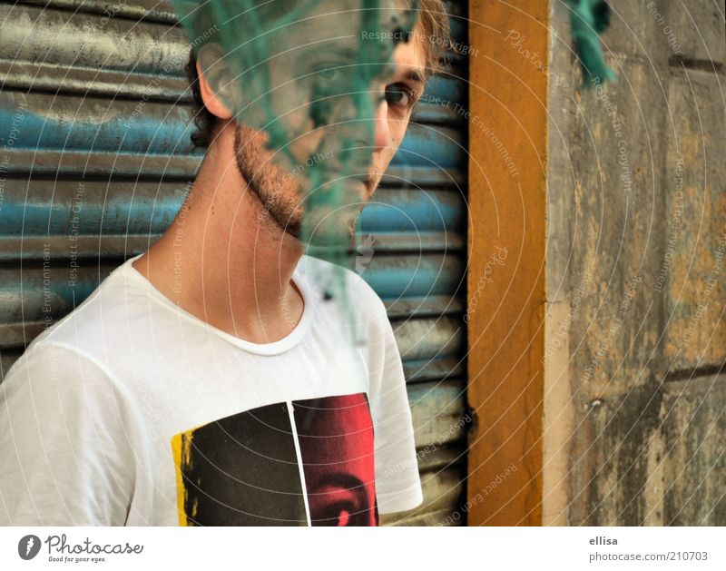 Einundhalb Augen maskulin Junger Mann Jugendliche 18-30 Jahre Erwachsene Mauer Wand T-Shirt beobachten entdecken Blick Neugier verstecken Fetzen Rollladen