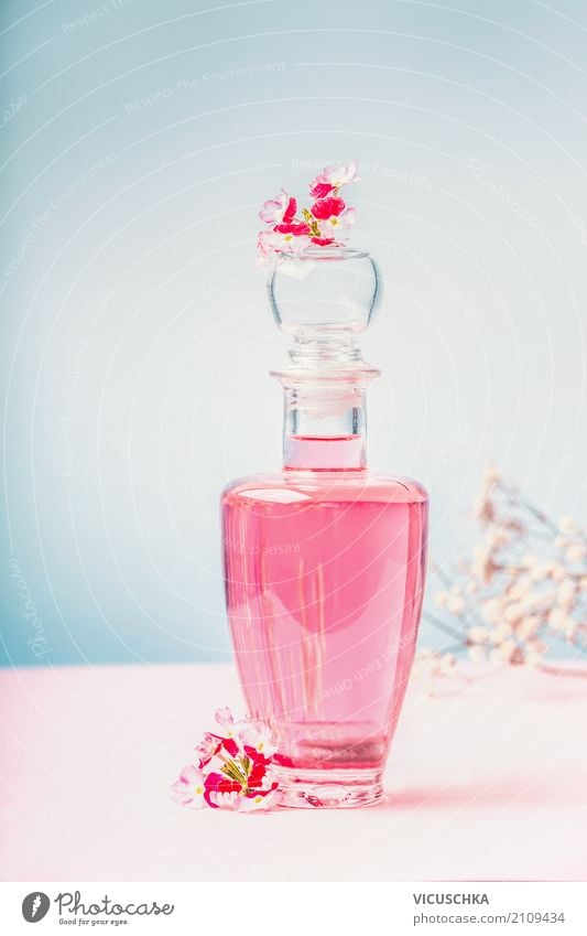 Flasche mit Lotion oder Parfüm mit rosa Blüten Lifestyle Stil Design schön Körperpflege Kosmetik Parfum Wellness Spa Massage Natur Blume Blatt aromatisch