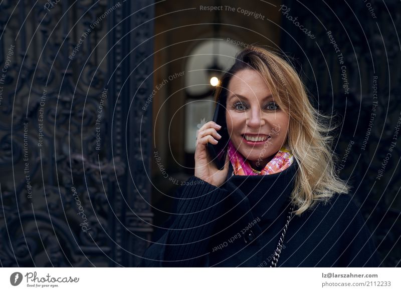 Frau, die in einer aufwändigen historischen Tür steht Stil Glück Winter Haus Business Telefon PDA Erwachsene 1 Mensch 30-45 Jahre Mantel blond hören