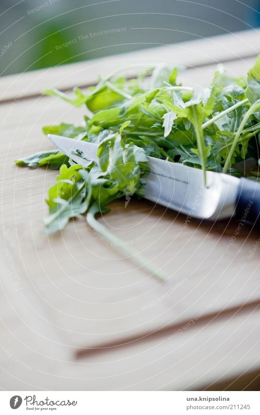 rucola Lebensmittel Gemüse Salat Salatbeilage Ernährung Bioprodukte Vegetarische Ernährung Messer grün geschnitten Rucola Holzbrett Gesunde Ernährung
