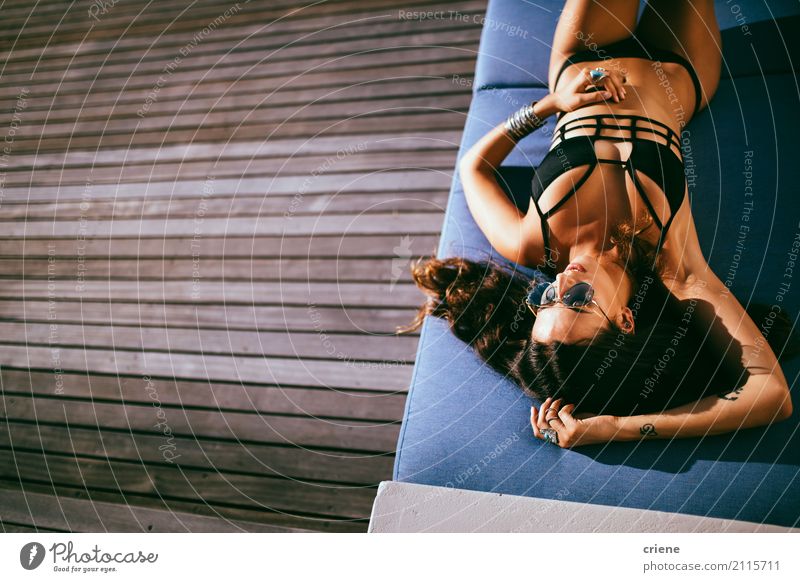 Frau, die im Bikini auf Balkon ein Sonnenbad nimmt und sich entspannt Lifestyle Freude Wellness Erholung Freizeit & Hobby Ferien & Urlaub & Reisen Sommer
