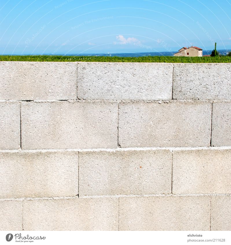 Auf der Mauer, auf der Lauer Landschaft Schönes Wetter Wand blau grau grün Ziegelbauweise Haus Größenunterschied Perspektive Ferne Farbfoto Menschenleer