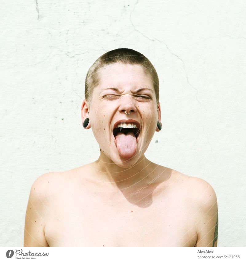 Junge Frau mit kurzen Haaren streckt die Zunge raus Lifestyle Stil schön Jugendliche Gesicht 18-30 Jahre Erwachsene Jugendkultur Subkultur Mauer Wand Schmuck
