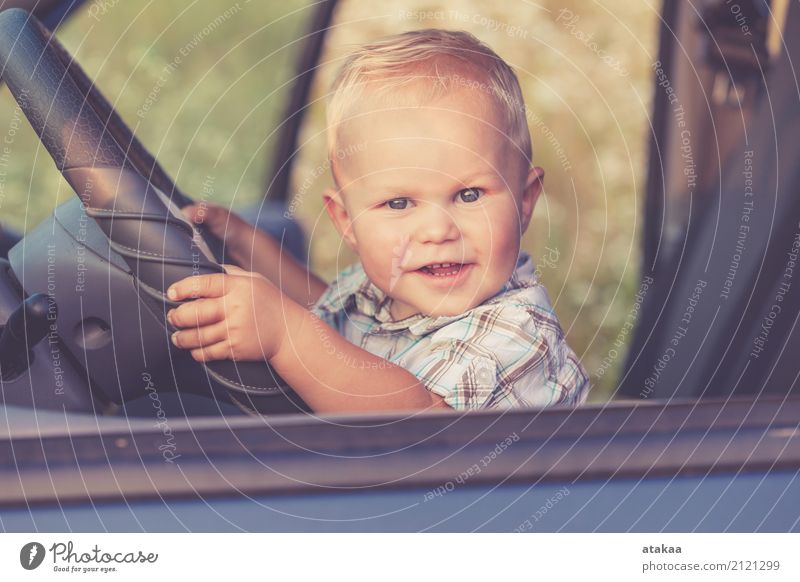 Ein kleiner Junge sitzt im Auto und schaut zur Tageszeit aus dem Autofenster. Konzept der glücklichen Reise. Lifestyle Freude Glück schön Leben Freizeit & Hobby