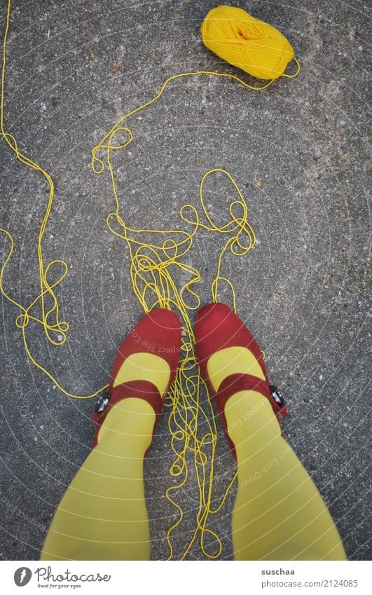 (zu)viel faden Schnur abgewickelt Wolle Wollknäuel Handarbeit drauf stehen Fuß Beine gelb rot Schuhe rote schuhe Asphalt Surrealismus