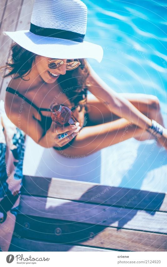 Schöne junge Frau, die Getränk am Swimmingpool genießt trinken Flasche Lifestyle Freude Glück Wellness Schwimmbad Ferien & Urlaub & Reisen Sommer Sonnenbad