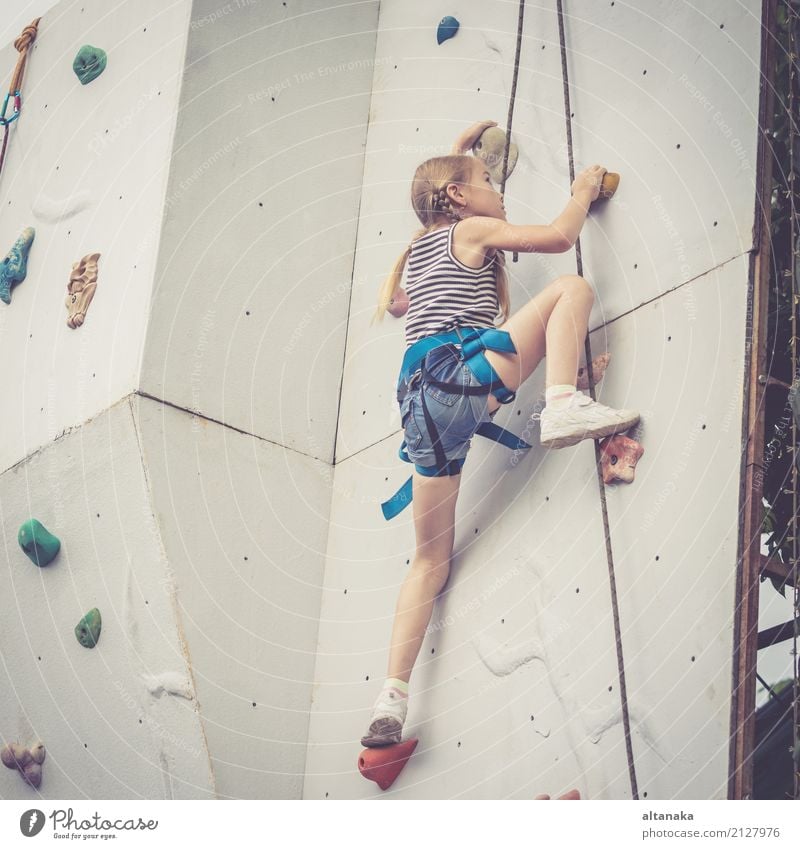 Kleines Mädchen klettert eine Felswand im Freien. Konzept des Sportlebens. Freude Freizeit & Hobby Spielen Ferien & Urlaub & Reisen Abenteuer Camping