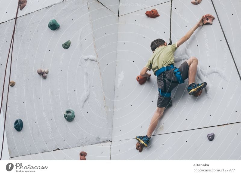 Kleiner Junge klettert eine Felswand im Freien. Konzept des Sportlebens. Freude Freizeit & Hobby Spielen Ferien & Urlaub & Reisen Abenteuer Camping