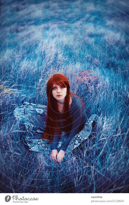 Junge Rothaarigefrau, die auf einem Feld des blauen Grases sitzt Mensch feminin Junge Frau Jugendliche 1 18-30 Jahre Erwachsene Natur Wiese Rock rothaarig