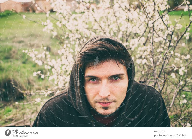 Junger Mann, der mit weißen Blumen als Hintergrund aufwirft Lifestyle Mensch maskulin Jugendliche 1 18-30 Jahre Erwachsene Natur Pflanze Frühling Klima