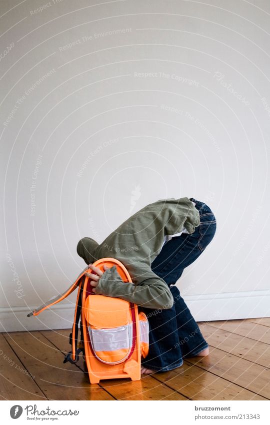 Kevin kotzt in den Ranzen. Mensch Mädchen 1 Mauer Wand Jeanshose Barfuß Gefühle Sorge Unlust Angst Schule Flucht verstecken Schulranzen Schulstart Farbfoto