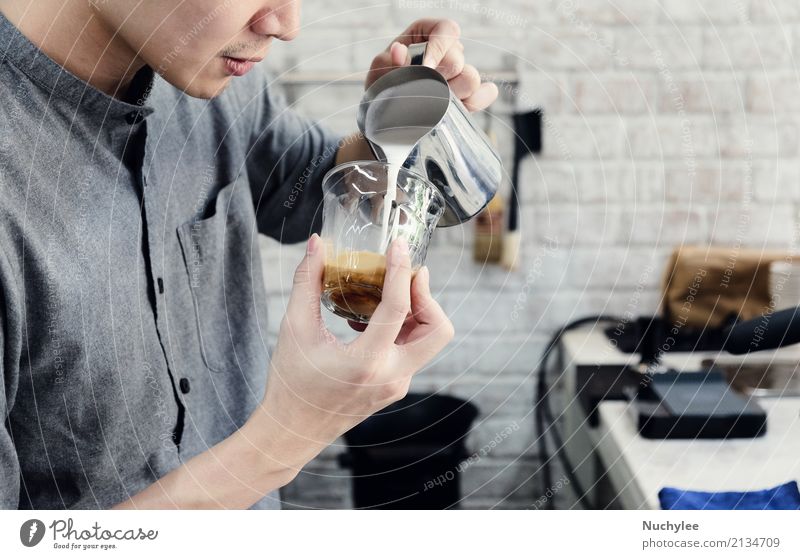 Hipster Barista gießt Milch für die Zubereitung von Cappuccino oder Milchkaffee im Café rustikal Cocktail Getränk gutaussehend Beruf jung männlich Kunst